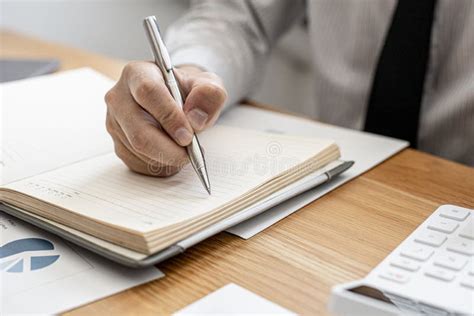 Close Ups Of A Businessman Taking Notes In A Notebook To Record