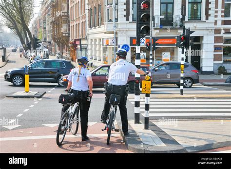 dutch police officers politie on bike patrol waiting at traffic