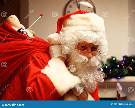 Portrait Of Happy Santa Claus Holding Sack With Ts And Looking At