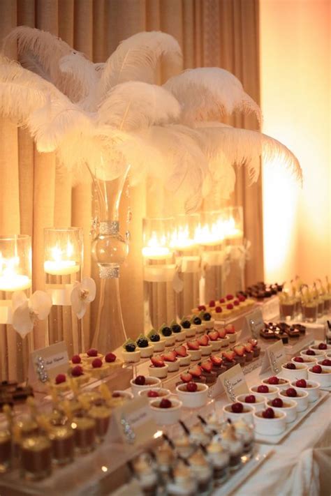 A Table Topped With Lots Of Desserts Next To Tall Vases Filled With Candles
