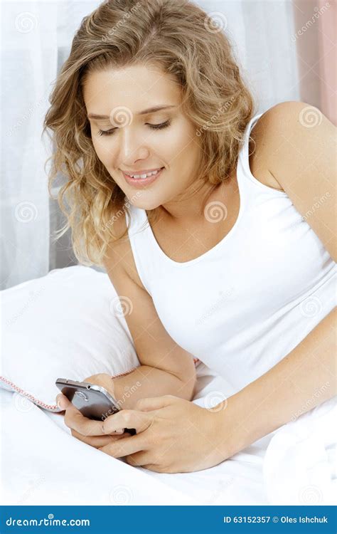 Young Beautiful Woman Lying In Bed With Her Phone Stock Image Image