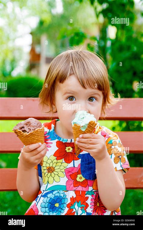 Cute And Happy Baby Girl With Two Ice Creams Outside Little Girl