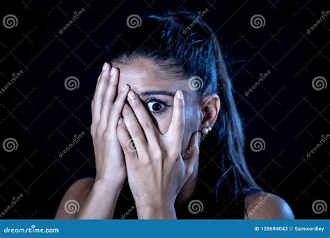 Scared Woman Covering Her Face With Hands Looking Through Her Fingers