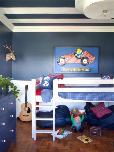 The blue bed sheet of this bed is complemented by the blue patterned area rug as well as the wooden bedside drawer and the mural on the wall by the entrance. Blue and Red Boy's Bedroom | HGTV