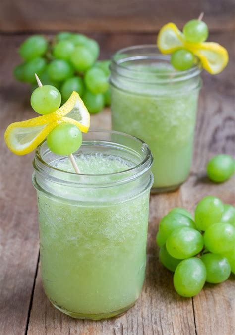 Two Mason Jars Filled With Green Grapes And Lemons