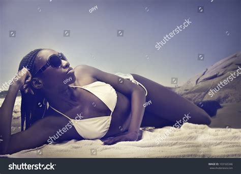 Beautiful African Woman Lying On A Beach And Sunbathing Stock Photo