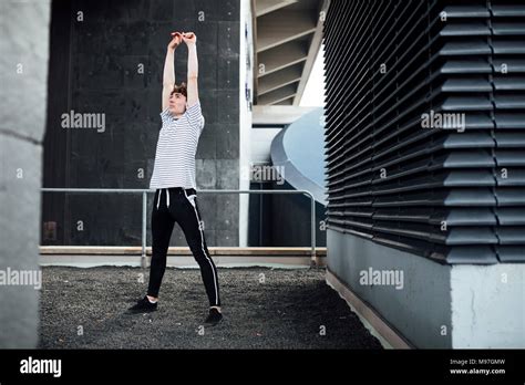 Freerunner Is Stretching On A Rooftop Stock Photo Alamy
