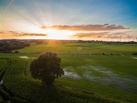 Aerial View Of A Beautiful Sunset With Sunbeams Above Green