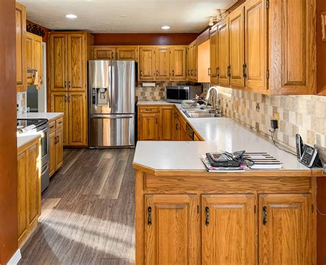 Costs depend on the cabinet layout and size, the painting method, the condition of the cabinets, and labor costs. Honey oak kitchen cabinets-05 - Painted by Kayla Payne