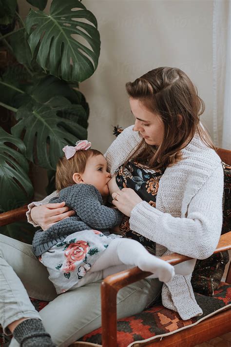 Mother Breastfeeding Young Daughter By Stocksy Contributor Leah Flores Stocksy