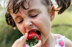 girl eating little stocksy strawberries united