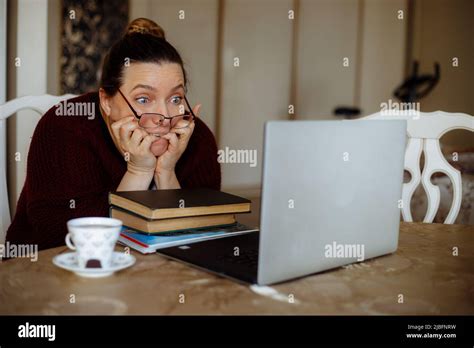 Portrait Of Frightened Scared Middle Aged Woman Sitting At Table