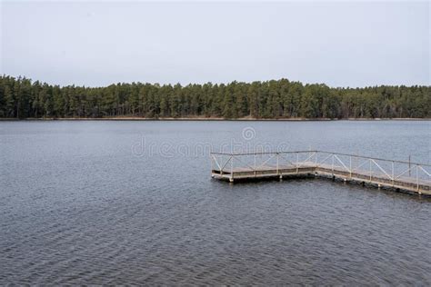 Quiet Lake In The Forest With A Pier In Cloudy Weather Stock Photo