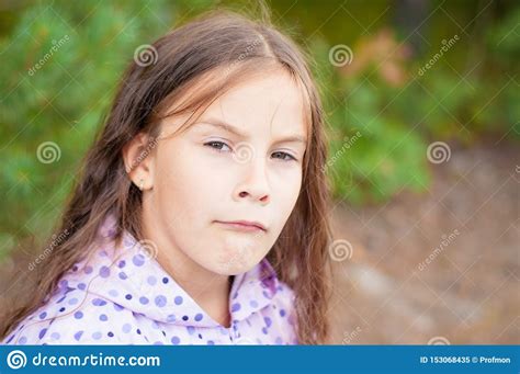 Sad Little Girl Is Looking With Serious Face At Camera Stock Image