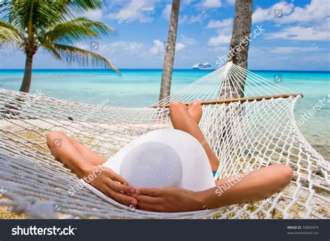 Woman Relaxing On Hammock With White Hat Sunbathing On Vacation Cancun