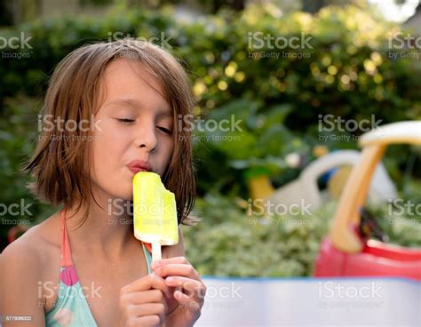 Caucasian Girl Eating Popcicle In Pool Stock Photo Download Image Now