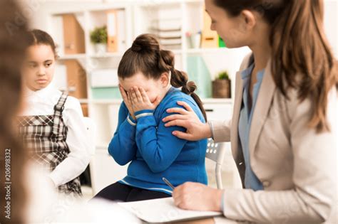 The Teacher Comforting The Sad Girl During A Lesson Stock Photo And
