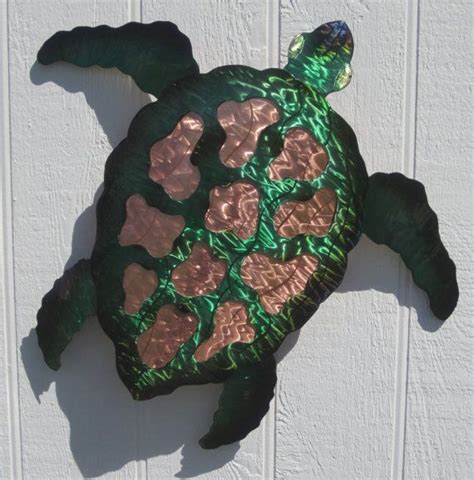 A Green And Gold Turtle Sculpture On The Side Of A White Building With