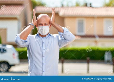 Portrait Of An Upset Man In Antivirus Mask On The Street Stock Photo