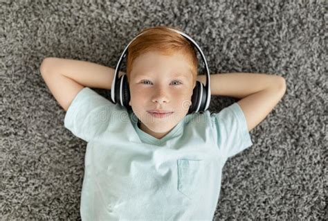 Portrait Of Happy Ginger Boy With Wireless Headset Top View Stock