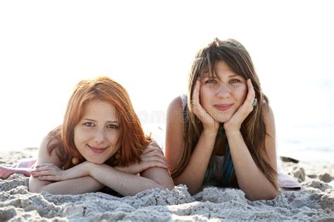 twee mooie meisjes liggen op het strand stock afbeelding image of kijk mooi 15154917