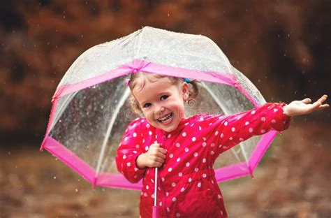 Happy Child Girl Laughing With An Umbrella In Rain Stock Photo Image