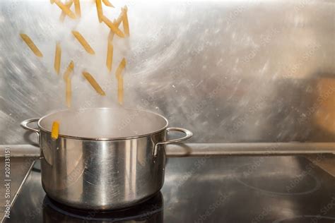 Penne Rigate Nudeln Fallen In Einen Kochtopf Mit Kochendem Wasser Stock