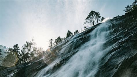 Wallpaper Waterfall Cliff Trees Sunlight Flare Hd