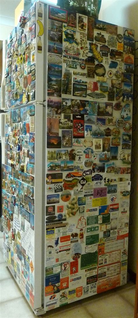 A Refrigerator Covered In Pictures And Magnets Sitting On The Side Of A