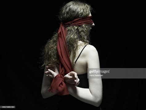 Young Woman Wearing Blindfold Arms Tied Behind Back Rear View Photo