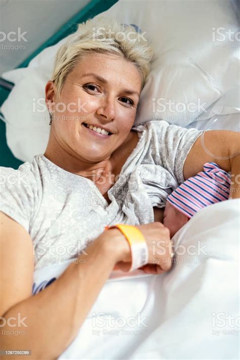 A New Mother Nursing Her Newborn Boy In The Hospital Stock Photo