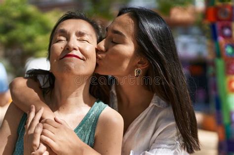 Two Women Mother And Daughter Hugging Each Other Kissing At Park Stock