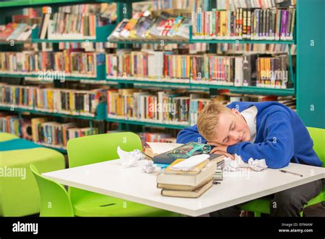 Exhausted Student Sleeping On Table In Library Stock Photo Alamy