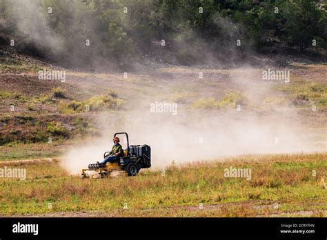 Man Mowing Dry And Dusty Pasture With Tractor Central Colorado Usa
