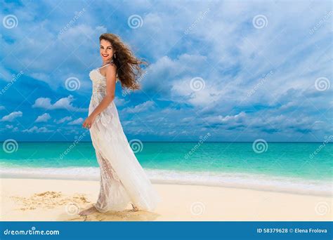 Beautiful Young Woman In White Dress With Umbrella On A Tropical Beach