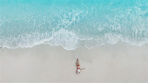 Aerial Top View Of Young Woman In A Red Bikini Lying On The Back On The White Sand Near The