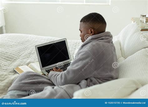 Man Using Laptop While Lying On Bed In Bedroom At Comfortable Home Stock Image Image Of