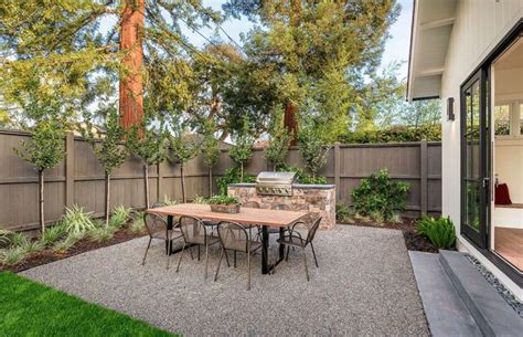 Backyard Gravel Patio With Dining Table And Outdoor Kitchen Stone