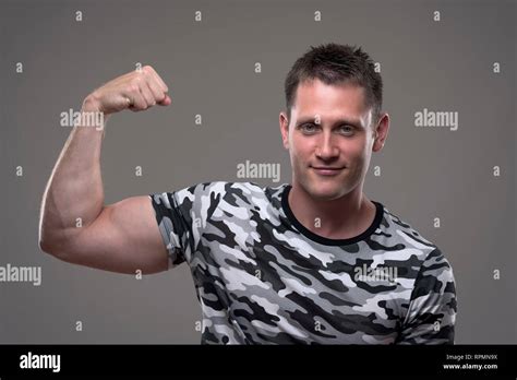 Portrait Of Athletic Muscular Fitness Male Model In Army Shirt Flexing