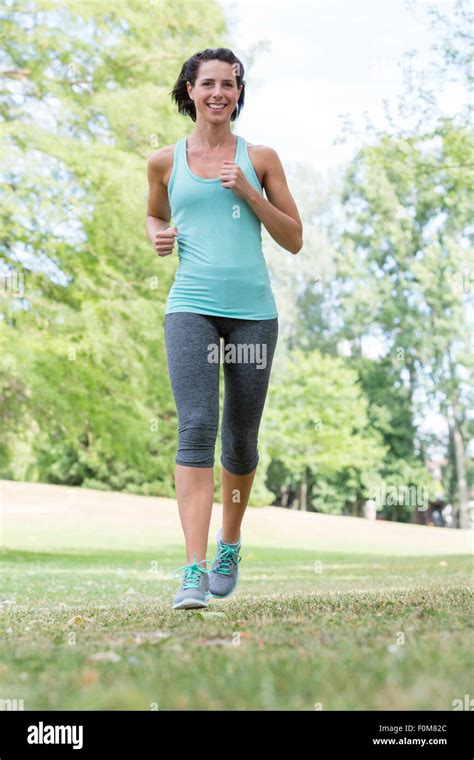 Woman Jogging Through The Park Stock Photo Alamy