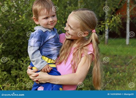 The Girl Holds A Little Boy In Her Arms Stock Image Image Of Cheerful