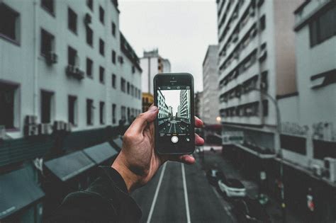 Man Holding Smartphone Capturing Roadway · Free Stock Photo