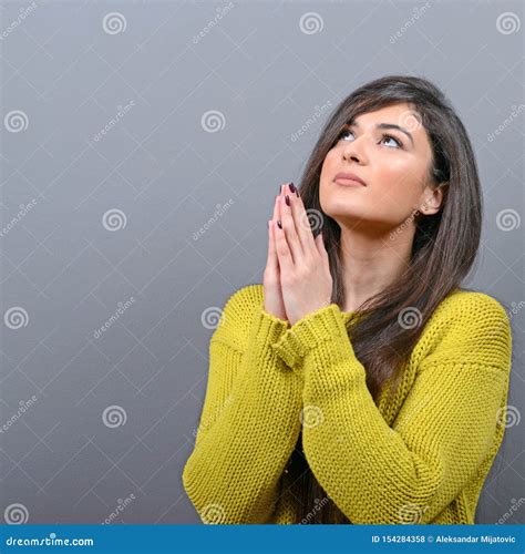 Woman Praying About Something Or Begging For Mercy Against Gray