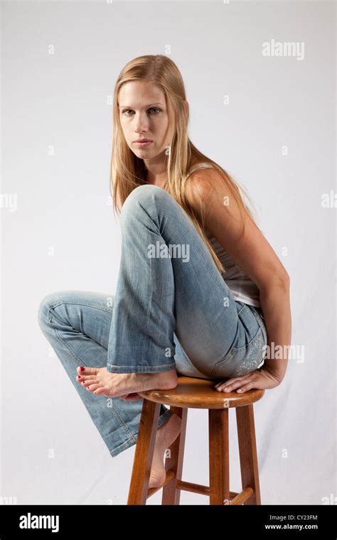 Pretty Blond Woman Sitting With Her Knee Up To Her Chest And Looking At