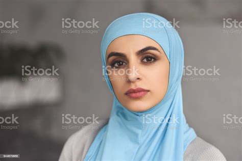 Portrait Of Beautiful Muslim Woman In Hijab Looking At Camera At Home