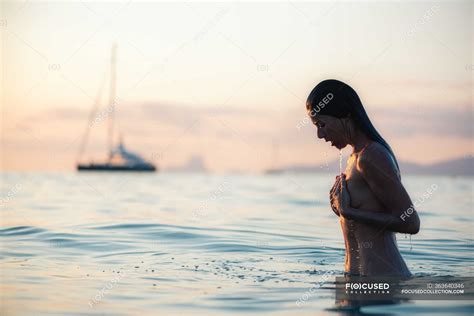 Naked Woman In Sea During Sunset Outdoors Sensual Stock Photo
