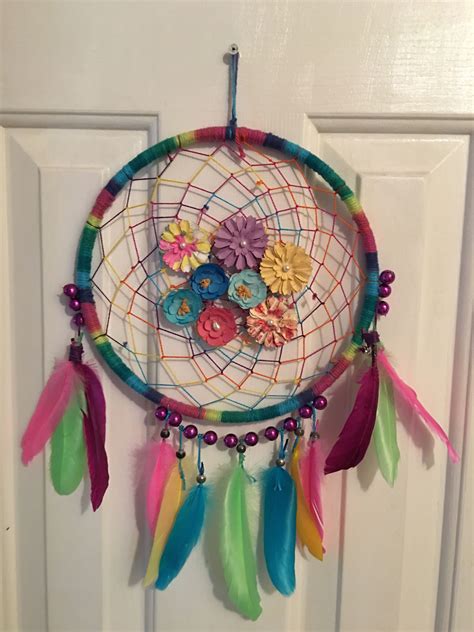 A Colorful Dream Catcher Hanging On The Front Door With Flowers And