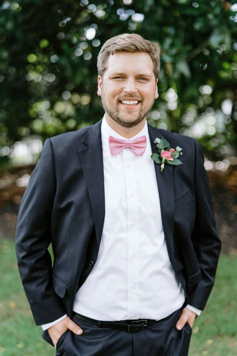 groom in black suit with pink bow tie historic wedding venue