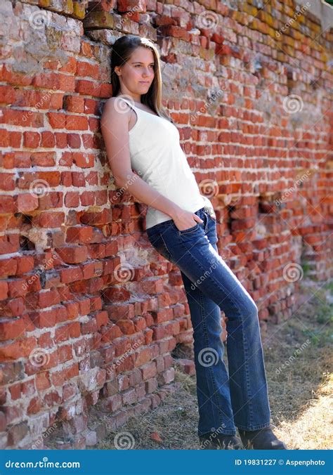 Young Woman Against A Brick Wall Stock Image Image Of Sultry Denim 19831227