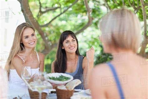 Women Eating At Table Outdoors Stock Photo Dissolve